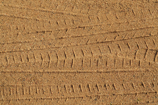 Tyre tracks on sandy road.
