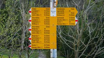 Yellow sign post with mountains in the Swiss Alps.