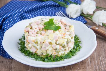 Classic Russian salad with sausage, peas, potatoes, carrots and mayonnaise, tasty traditional dish,snack.