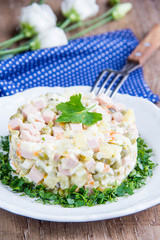 Classic Russian salad with sausage, peas, potatoes, carrots and mayonnaise, tasty traditional dish,snack.