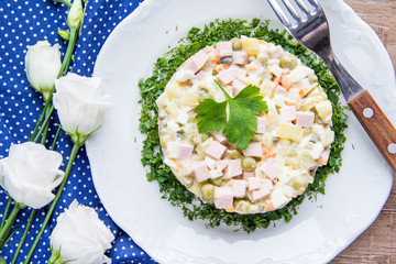 Classic Russian salad with sausage, peas, potatoes, carrots and mayonnaise, tasty traditional dish,snack.