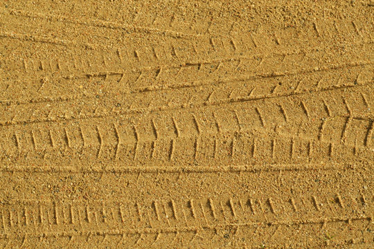 Tyre tracks on sandy road.