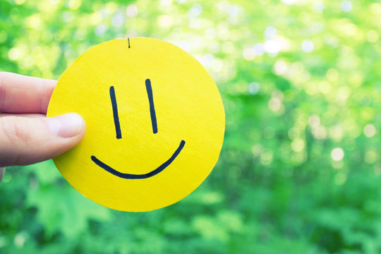 yellow smile on green leaves background