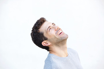 Obraz premium Close up young man looking up and laughing on white background
