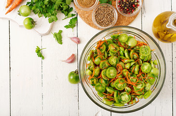 Korean salad from green tomatoes and carrots. Flat lay. Top view
