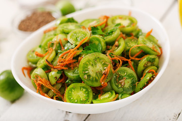 Korean salad from green tomatoes and carrots.