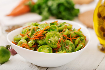 Korean salad from green tomatoes and carrots.