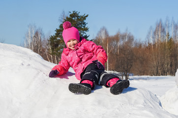 Fototapeta na wymiar Cheerful little girl on a walk a clear winter day