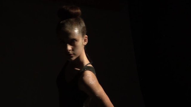 Brunette teenager in sequins dancing in the dark, slow motion