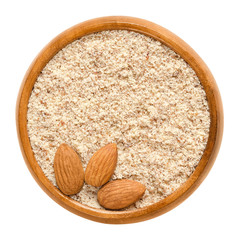 Shelled and ground almond nuts in wooden bowl. Edible, dried, brown seeds of Prunus dulcis....