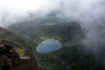 Fototapeta premium Heavy fog in the early morning on a mountain lake Early morning in the Ergaki national park, Russia