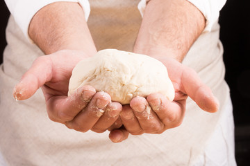 Baker holds raw dough in hands