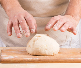 Baker makes dough for bread
