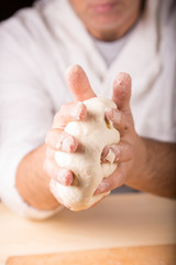 Baker holds raw dough in hands