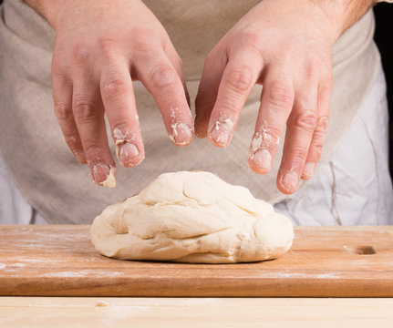 Baker makes dough for bread