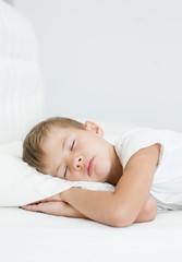 Obraz na płótnie Canvas little boy sleeping in bed. Space for text