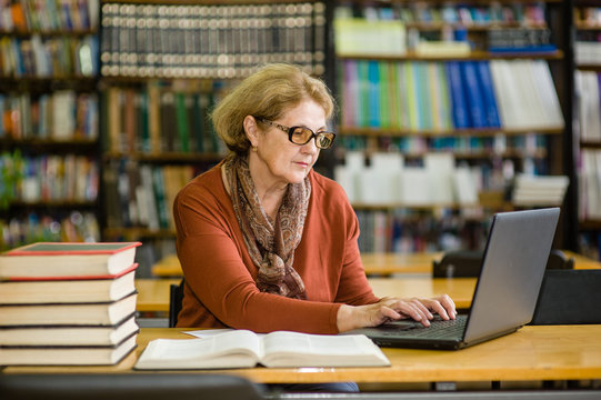 Senior woman using laptop in library