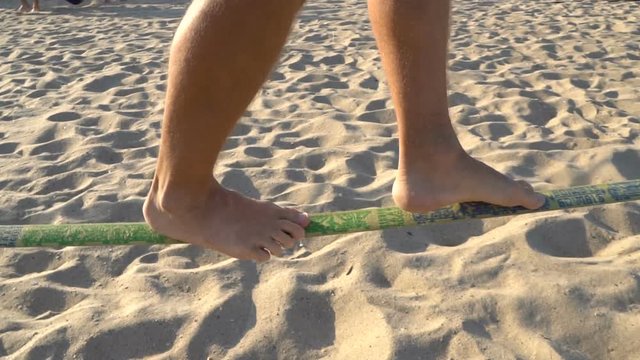 Legs of Man Walking on The Rope at the Extreme sports festival. Slackline walk