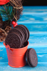Decorative red pail with chocolate cookies on the table