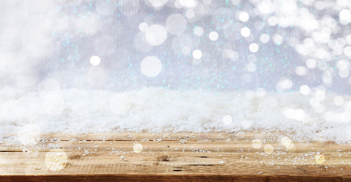 Christmas snowy bokeh background over wooden surface