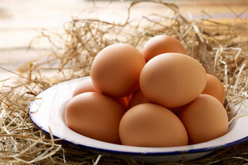 Collected brown chicken eggs on white plate