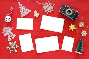 Top view image of christmas festive decorations next to old camera and empty photo frames. For...