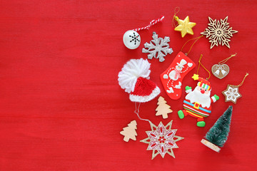Top view image of christmas festive decorations on red wooden background. Flat lay.
