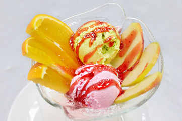 Two ice cream balls with fruits.