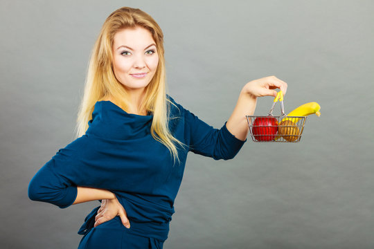 Woman holding shopping basket with fruits inside