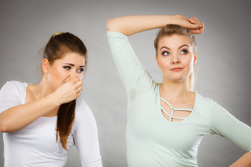 Woman having wet armpit her friend smelling stink