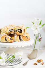 Poppy seeds croisssants. Traditional, polish croissants. White background, white wooden table and white plates.
