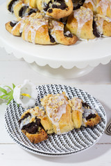 Poppy seeds croisssants. Traditional, polish croissants. White background, white wooden table and white plates.