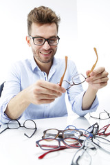 Młody mężczyzna przymierza okulary  © doroguzenda