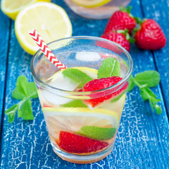 Strawberry mint homemade lemonade on wooden table, square format