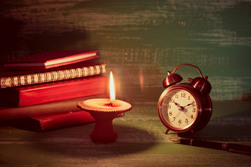 still life candlestick on old book with alarm clock on wood