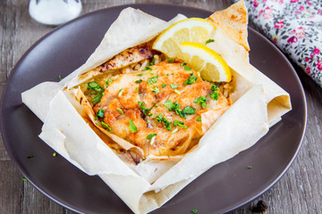 White fish fillet baked in parchment with rice and vegetables, tasty healthy dish, diet food