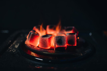 hot coals for Shisha warmed up on the stove in a hookah bar