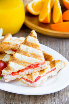 Grilled sandwich, toast with cheese, ham and tomato, tasty European Breakfast with orange juice, food