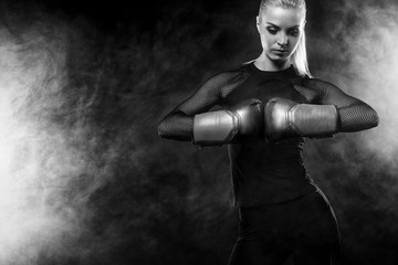 Fototapeta na wymiar A strong athletic, woman boxer, boxing at training on the black background. Sport boxing Concept with copy space.