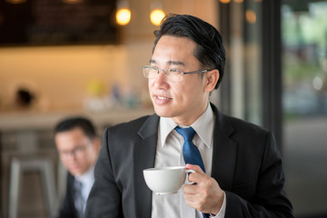 Portrait of handsome business man drinking coffee in cafe