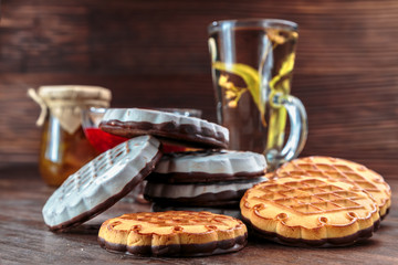 cookies with white chocolate frosting and raspberry jam in a little vase on the table for tea