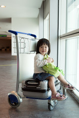 Little Asian baby with luggage at airport