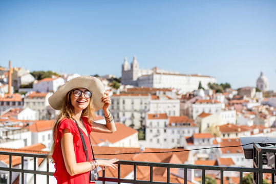 Young woman tourist enjoying beautiful cityscape view on the Alfama region of Lisbon city during the morning light in Portugal