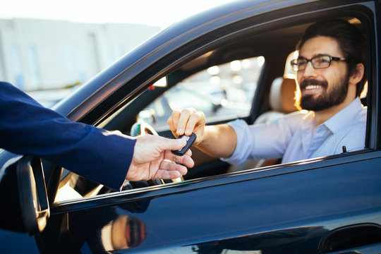 Young and handsome businessman buying used car