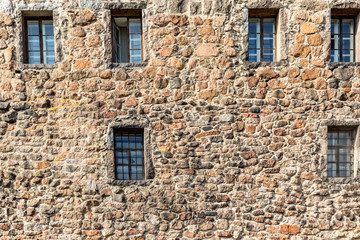 Fototapeta na wymiar Gated window on the wall of an old building