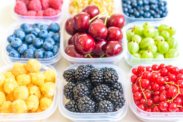 Collage of different fruits and berries isolated on white. Blueberries, cherries, blackberries, grapes, strawberries, currants. Collection of fruits and berries in a bowl. Top view