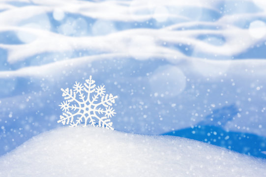 Christmas background with decorative snowflake among snowdrifts