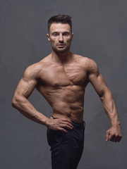 Fototapeta premium A physically strong man in black trousers and a naked torso.