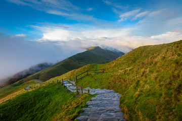 Beautiful autumn scenery in the Peak District - sunrise at Mam Tor - public cobblestone walkway going dowhill