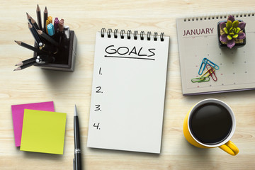 New Year goals, resolutions or action plan concept. Notebook on office table with calendar, coffee,...